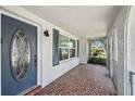 Charming front porch featuring a decorative front door, unique mosaic tile flooring, and an arched doorway at 7553 Sequoia Dr, New Port Richey, FL 34653