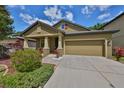 Attractive single-Gathering home featuring covered porch, 2-car garage, concrete driveway and colorful landscaping at 838 Vino Verde Cir, Brandon, FL 33511