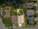 Aerial view of the property showing the roof, driveway, and surrounding greenery and neighboring houses at 1211 Penny Ct, Dunedin, FL 34698