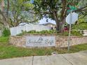 Scottsdale Bluffs Deed Restricted Community sign surrounded by greenery and trees on a sunny day at 1211 Penny Ct, Dunedin, FL 34698