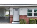 Inviting front entrance with a white door, brick accents, and convenient carport access at 12400 Park Blvd # 121, Seminole, FL 33772