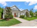 Attractive home with a covered porch, bright red front door, and lush green lawn and landscaping at 1511 47Th N Ave, St Petersburg, FL 33703