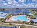 Aerial view of a resort-style pool with a splash fountain, plenty of seating and lush palm trees at 2117 Lake Waters Pl, Lutz, FL 33558