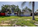 Attractive single-Gathering home with lush landscaping, blue shutters and an attached garage at 2131 Cedar Dr, Dunedin, FL 34698