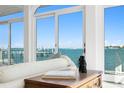 Bright living room with tile floor and large glass doors revealing beautiful water view at 2171 E Vina Del Mar Blvd, St Pete Beach, FL 33706