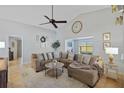 Bright living room with vaulted ceilings, large sectional sofa, and a decorative clock at 3106 Whispering S Dr, Largo, FL 33771