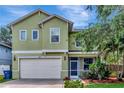 Charming two-story home features a two car garage, well-manicured lawn, and inviting front porch, providing a welcoming curb appeal at 3408 W Bay Ave, Tampa, FL 33611