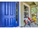 Inviting front porch showcasing a blue front door and seating area, perfect for relaxing and enjoying the outdoors at 3408 W Bay Ave, Tampa, FL 33611