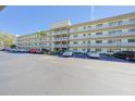 Four-story condo complex with parking in front of the building on a sunny day at 6070 80Th N St # 406, St Petersburg, FL 33709
