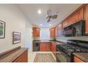 Cozy kitchen with wood cabinets, modern appliances, and a ceiling fan at 6070 80Th N St # 406, St Petersburg, FL 33709