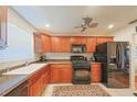 Kitchen featuring wood cabinets, black appliances, and a sink below the window at 6070 80Th N St # 406, St Petersburg, FL 33709