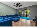 Comfortable living room with blue sectional, ceiling fan, and access to the outdoor balcony at 6462 92Nd N Pl # 804, Pinellas Park, FL 33782