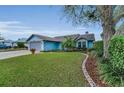 Charming light-blue house features a well-maintained lawn and landscaping at 8742 Bermuda Ln, Port Richey, FL 34668