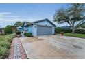 Light-blue house with well-manicured landscaping and a gray two-car garage at 8742 Bermuda Ln, Port Richey, FL 34668