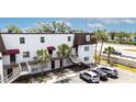 White two-story building with brown accents, surrounded by lush palm trees and well-maintained parking at 9001 Tudor Dr # H210, Tampa, FL 33615