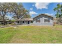 Charming single-story home featuring a grey brick exterior, a well-kept lawn, and mature trees at 904 Tomlinson Dr, Lutz, FL 33549