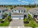 Aerial view of a spacious two-story home with three-car garage and a beautiful, landscaped yard at 933 Signet Dr, Apollo Beach, FL 33572