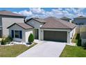 An elevated view of a single-story home with a manicured lawn and neutral color palette at 9433 Channing Hill Dr, Sun City Center, FL 33573