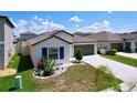 Attractive single-story home featuring a well-kept lawn, landscaping, and a two-car garage at 9433 Channing Hill Dr, Sun City Center, FL 33573