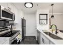 Modern kitchen with stainless steel appliances, white cabinets, and dark backsplash at 1000 W Horatio St # 207, Tampa, FL 33606