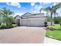 Beautifully landscaped two-story home with a three-car garage and a charming brick driveway at 10703 Morning Dew Way, Tampa, FL 33647
