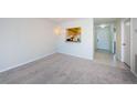 Bright living room features neutral carpet, chandelier, and open view to kitchen at 1805 Mariner Dr # 52, Tarpon Springs, FL 34689