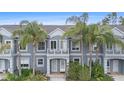 Charming townhome featuring a private balcony and lush landscaping with palm trees at 18111 Paradise Point Dr, Tampa, FL 33647