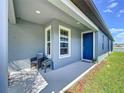 Inviting front porch featuring a chair and table, offering a cozy spot to relax outdoors at 20983 Monza Loop, Land O Lakes, FL 34638