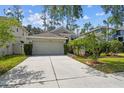 Charming single-story home featuring a two-car garage, well-manicured lawn, and mature trees at 21840 Waverly Shores Ln, Land O Lakes, FL 34637