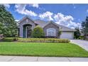 Charming home featuring well manicured lawn, stone accents, and beautiful mature landscaping at 22338 Bartholdi Cir, Land O Lakes, FL 34639
