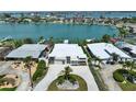 An aerial view captures this coastal home showcasing an elegant circular driveway and bay access at 25 Dolphin Dr, Treasure Island, FL 33706