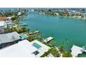 An aerial view showcasing waterfront property with a private pool and direct access to the Gulf of Mexico at 25 Dolphin Dr, Treasure Island, FL 33706