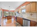 Inviting kitchen with stainless steel appliances, wood cabinets, and backyard pool view at 3626 Lake Joyce Dr, Land O Lakes, FL 34639