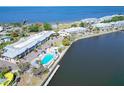 Aerial view of waterfront condos with a pool, surrounded by lush landscaping and ocean views at 611 Destiny Dr # 205, Ruskin, FL 33570