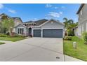 Charming single-story home featuring a stone accent entry, well-manicured lawn, and a two-car garage at 6611 Current Dr, Apollo Beach, FL 33572