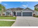 Charming single-story home featuring a stone accent entry, well-manicured lawn, and a two-car garage at 6611 Current Dr, Apollo Beach, FL 33572
