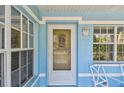 Close-up of the front door surrounded by windows, providing natural light and curb appeal at 711 6Th Ne St, Largo, FL 33770