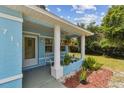 Inviting front porch with white columns and seating area, perfect for enjoying the outdoors at 711 6Th Ne St, Largo, FL 33770