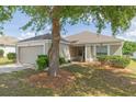 Charming single-story home with a two-car garage and a well-maintained lawn with mature shade trees at 7939 Merchantville Cir, Zephyrhills, FL 33540