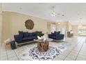 Comfortable living room with stylish furniture, decorative mirror, ceiling fan, and views of the front foyer at 9395 Belvedere St, Spring Hill, FL 34608