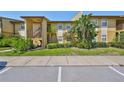 Charming exterior view of the tan condo featuring lush landscaping and ample parking at 10100 Sailwinds N Blvd # 203, Largo, FL 33773