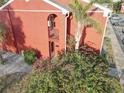 Exterior angled view of a two story condo with red brick, stairs, tropical plants, and a private entry at 1095 82Nd N Ter # 1095A, St Petersburg, FL 33702