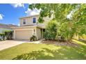 Two-story home with well-kept lawn, two-car garage, and tidy landscaping at 11231 Spring Point Cir, Riverview, FL 33579