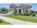 A charming two-story home features an expansive lawn, lush bushes, and a welcoming entrance at 13121 Pasture View Loop, Riverview, FL 33579
