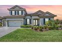 Charming two-story home with a well-manicured lawn, a two-car garage, and a tile roof at 13121 Pasture View Loop, Riverview, FL 33579