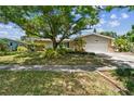 Well-maintained single-Gathering home featuring a spacious two-car garage and manicured front lawn at 1320 Whispering Pines Dr, Clearwater, FL 33764