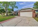 Charming single-story home featuring a well-manicured lawn, brick accents, and an attached two-car garage at 13308 Kearney Way, Tampa, FL 33626