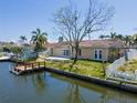 The rear of the home faces the canal, featuring a patio and wooden dock at 1419 47Th Ne Ave, St Petersburg, FL 33703