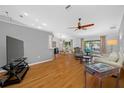 Bright and airy living room boasting hardwood floors, a ceiling fan, and sliding glass doors to the outside at 1610 Navigator Ln, Tarpon Springs, FL 34689