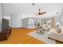 Bright living room with hardwood floors, modern furniture, and ceiling fan at 1610 Navigator Ln, Tarpon Springs, FL 34689